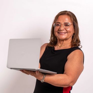 Smiling woman holding a laptop and looking confident.