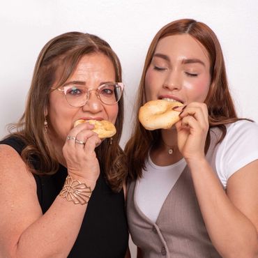 Two women enjoying bagels together in a friendly setting.