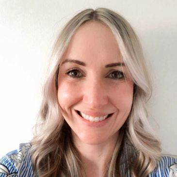Smiling woman with long blonde hair and a striped shirt.