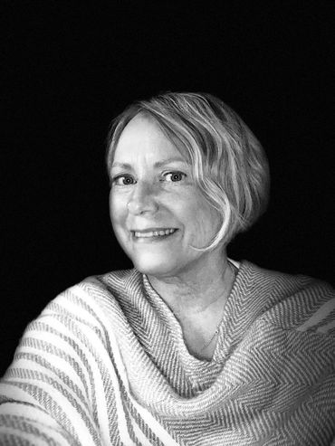 Black and white portrait of a smiling woman with short hair.