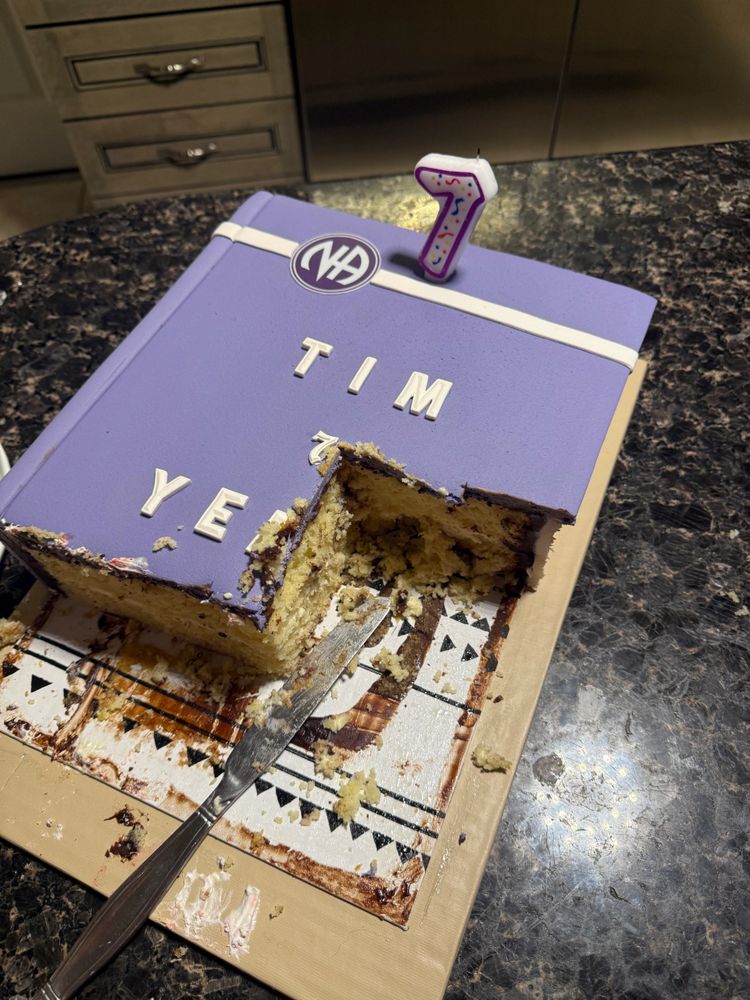 Partially eaten purple cake with a '7' candle on top.