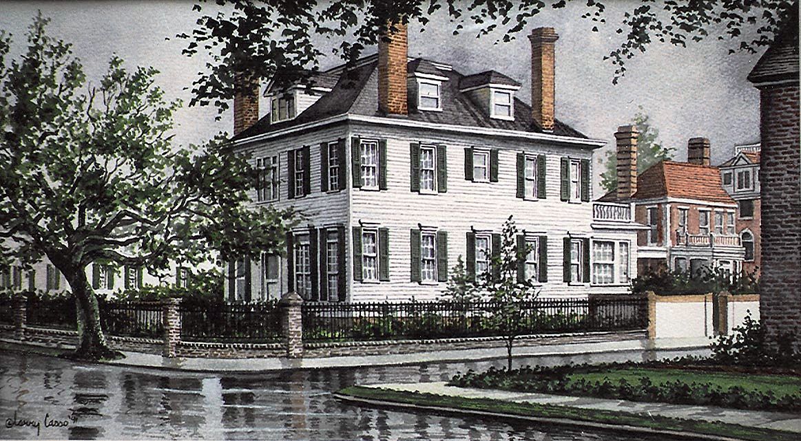 Traditional two story home in Charleston on a corner with rain puddles and reflections in the street