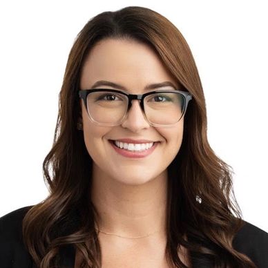 Smiling woman with glasses and brown hair.