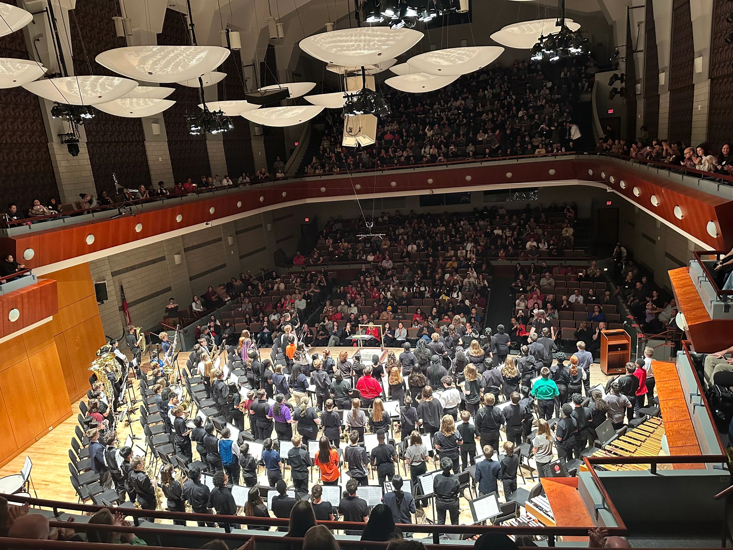 A packed concert hall during a band performance.