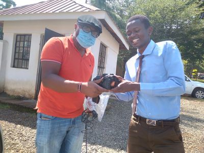 Dr. Luvai, left, donating a camera to Lung'afa. He tasked the camera to capture the best of sights.