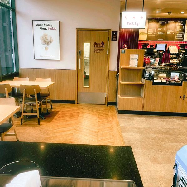 Cozy café interior with wooden furniture and a pick-up counter.