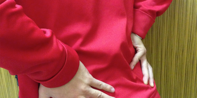 Showing a person holding their lower back in pain