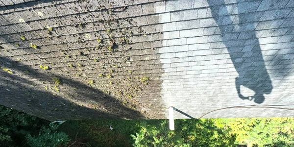 Shadow of a person making a heart shape with hands on a tiled roof.