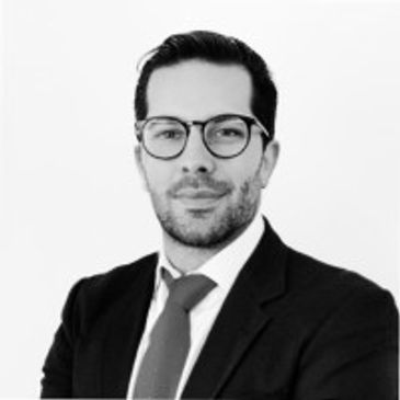 Professional man in a suit and glasses posing for a portrait.