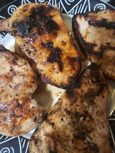 Close-up of grilled chicken breasts with char marks.