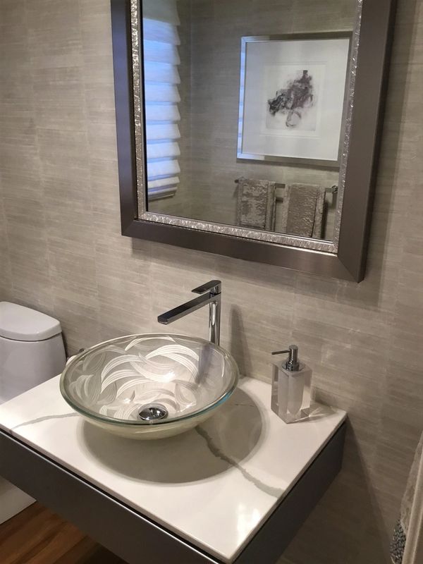 Remodeled bathroom with raised sink and framed mirror