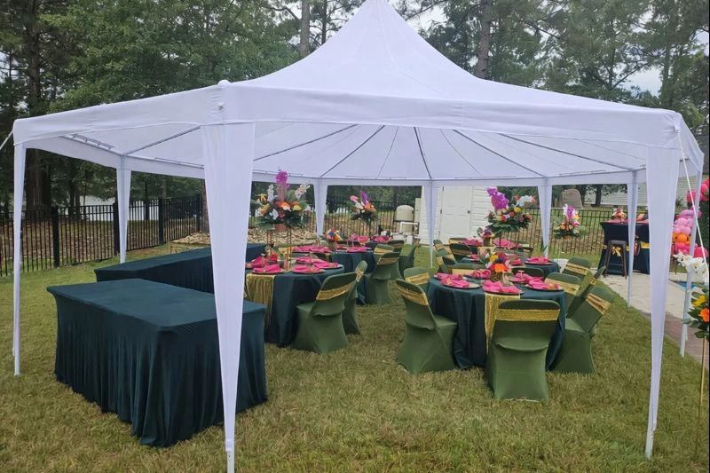 Beautifully white party tent with round tables and chairs.