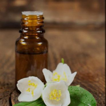 CALMIST BOTTLE OF ESSENTIAL OIL AND JASMINE FLOWERS