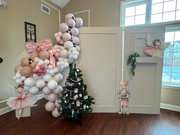 Nutcracker-themed holiday decoration with balloons, ballerina, and Christmas tree.
