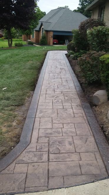 Ashlar slate stamped concrete sidewalk with borders, tan color, walnut release.