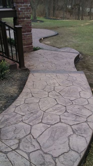 Stamped, decorative concrete steps, random stone pattern with borders.  Tan color, nutmeg release