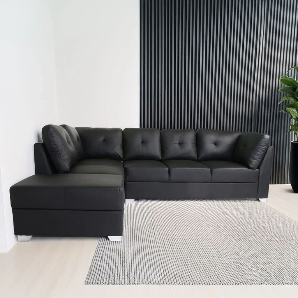 Modern black leather sectional sofa with tufted cushions.