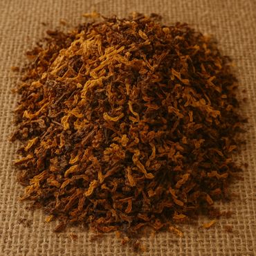 Pile of dried tobacco leaves on burlap fabric.