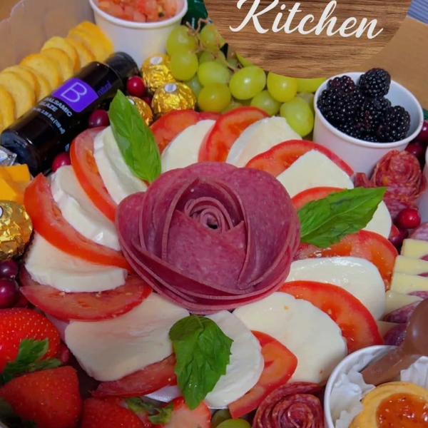 A vibrant charcuterie board with meats, cheeses, fruits, and garnishes arranged artistically.