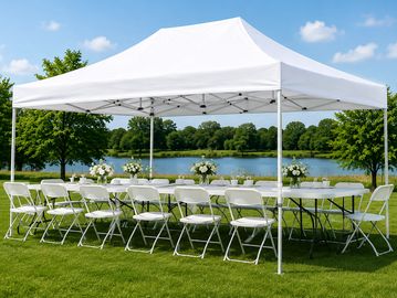 Outdoor event table setup under a white canopy.