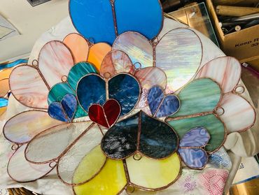 Colorful stained glass hearts arranged in a cluster.