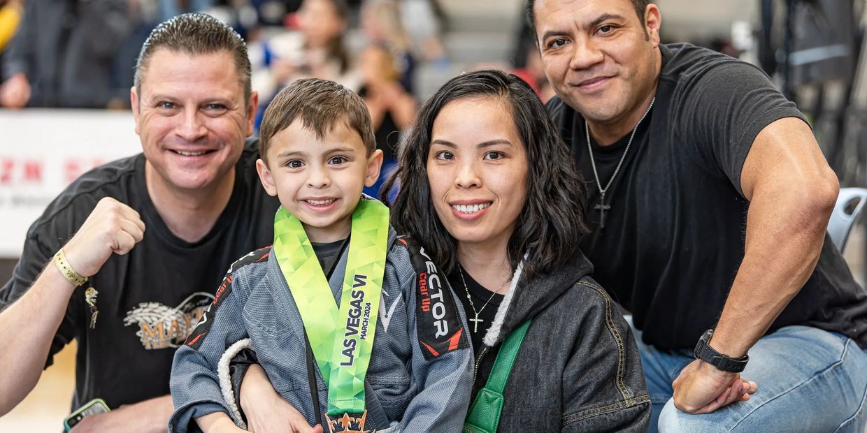 Happy boy with medal and proud supporters at event.