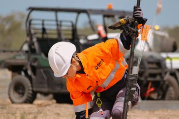 EMRO employee marking out survey points for pile testing with ATV in background