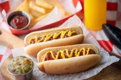 Two hot dogs with mustard and ketchup, fries, and a drink.