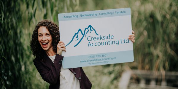 Kelowna accountant Jillian, CPA, CA with Creekside sign