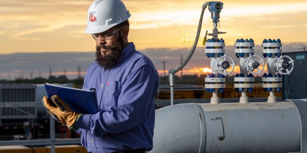 Engineer inspects equipment at sunset.