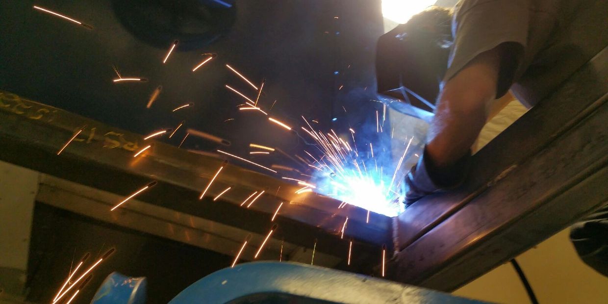 Person welding metal with sparks flying.