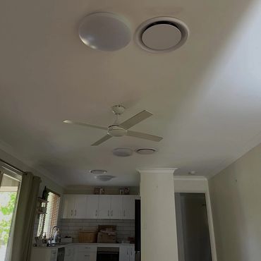 Ceiling fan and lights installed in a kitchen with white cabinets.