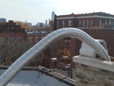 Flexible metal duct pipe extending from rooftop chimney.