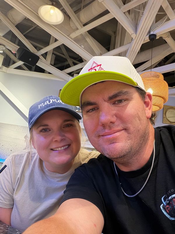 Smiling couple wearing caps indoors.