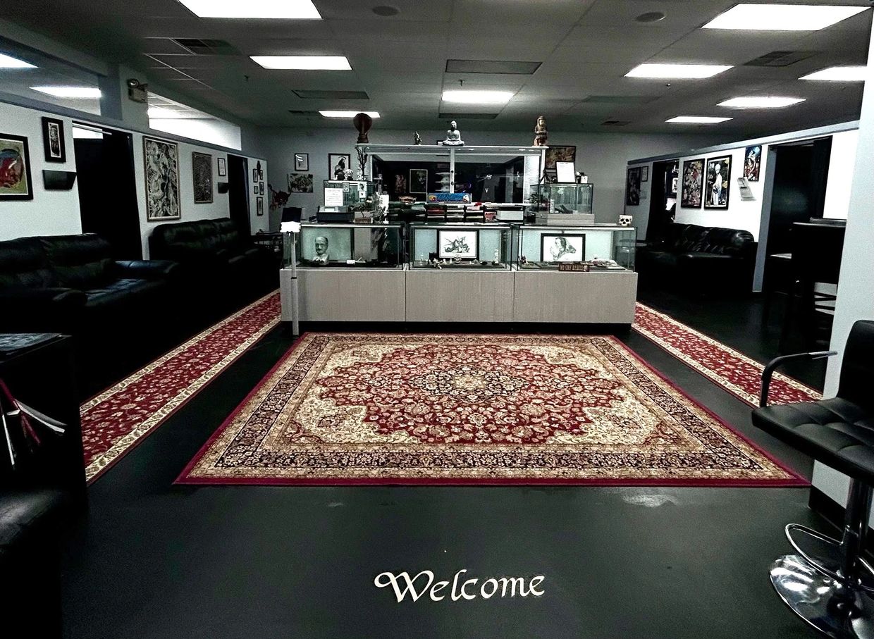 Tattoo studio waiting area with display cases and artwork.