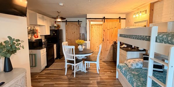 Cozy kitchen and dining area with bunk beds in a rustic-style cabin.
