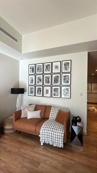 Cozy living room with leather sofa and black-and-white family photos.