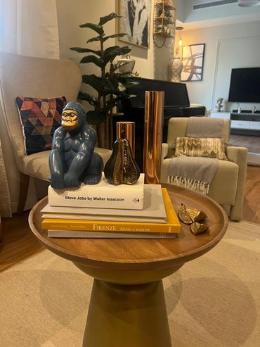 Expert re-decorating and styling service featuring a beautifully styled living room table with curated books, a unique gorilla sculpture, and elegant golden accents. Perfect for Dubai homeowners and landlords seeking affordable yet sophisticated home makeover solutions that elevate rental and residential spaces.
