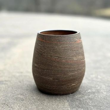 Multi-color stoneware cup made of different colored clays.
