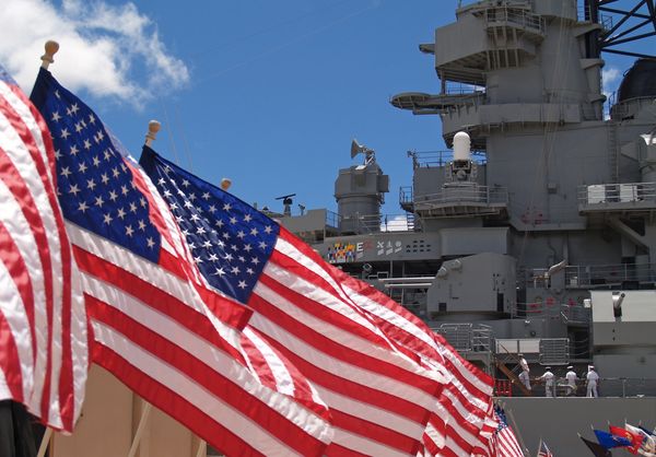 American flags beside navy ship.