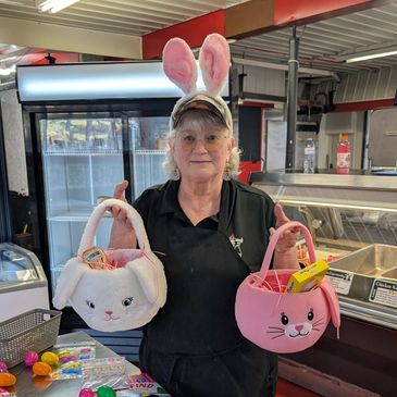 Woman with bunny ears holding two Easter baskets.
