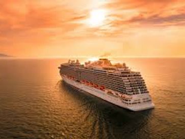 A large cruise ship sailing at sunset on calm waters.