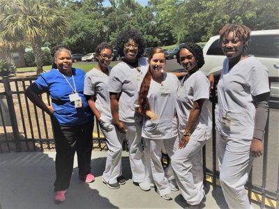 Group of healthcare workers smiling outdoors.