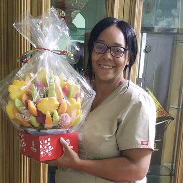 Woman holding a wrapped fruit bouquet gift.
