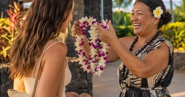 Traveler receiving a fresh orchid lei at Kona International Airport on the Big Island