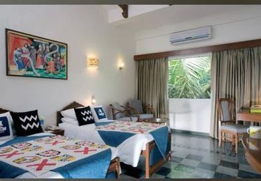 Cozy bedroom with twin beds, colorful quilts, and tropical view.