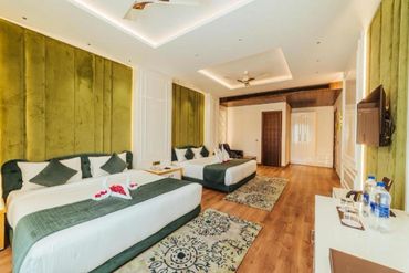 Spacious hotel room with two large beds and elegant decor.