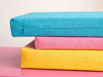 Fabric-covered cushions demonstrating bespoke textile covering, precision craftsmanship and custom fabrication.
