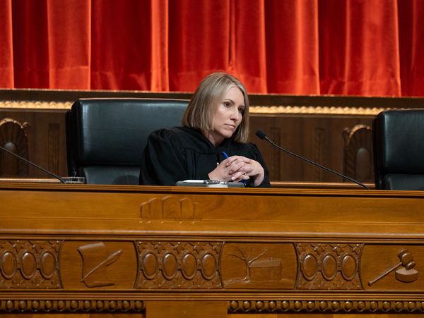 A female judge in a courtroom with a serious expression.