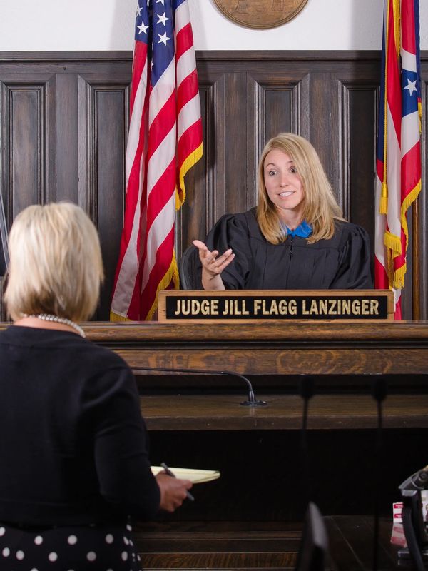 Judge Jill Flagg Lanzinger speaking to a woman in a courtroom.